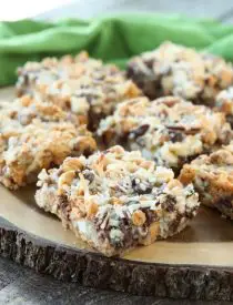 Seven Layer Bars, magic cookie bars, kitchen sink bars, whatever you call them, this classic dessert is easy and delicious. A graham cracker crust, chocolate, white chocolate, and butterscotch chips, nuts, and shredded coconut are melded together with sweetened condensed milk.