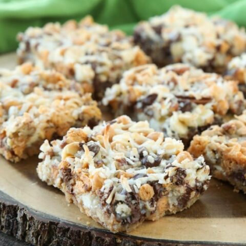 Seven Layer Bars, magic cookie bars, kitchen sink bars, whatever you call them, this classic dessert is easy and delicious. A graham cracker crust, chocolate, white chocolate, and butterscotch chips, nuts, and shredded coconut are melded together with sweetened condensed milk.