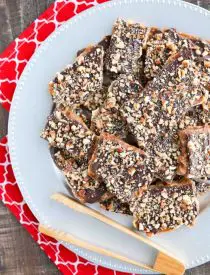 Cracker Toffee (aka Christmas Crack) is so easy to make and highly addictive! Saltine crackers are coated in a quick toffee layer and topped with chocolate and nuts. 