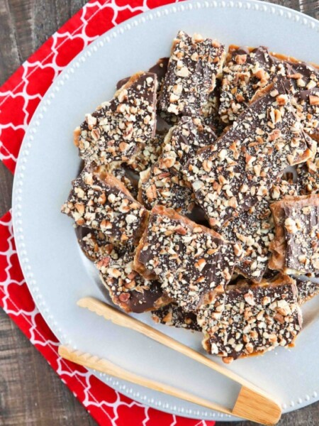 Cracker Toffee (aka Christmas Crack) is so easy to make and highly addictive! Saltine crackers are coated in a quick toffee layer and topped with chocolate and nuts.