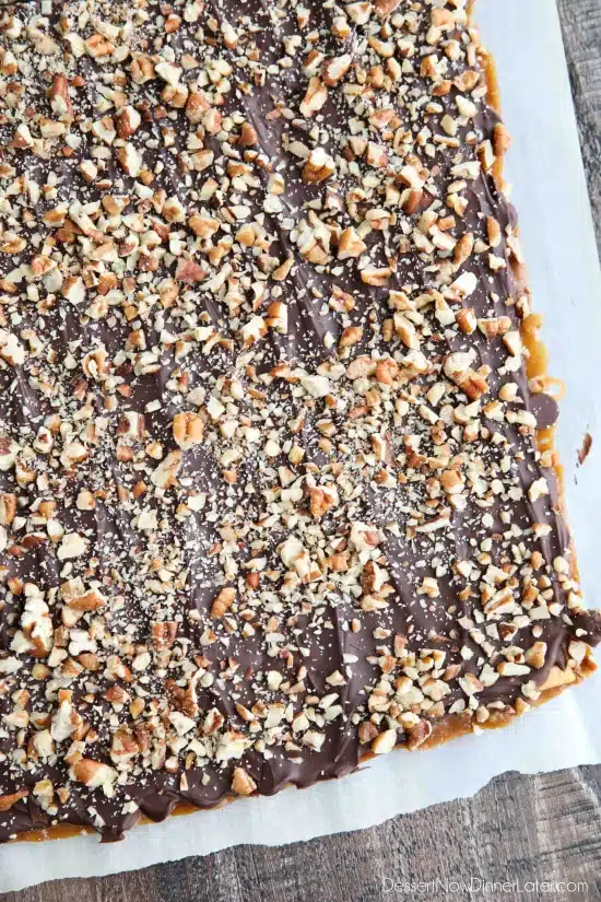 Cracker Toffee (aka Christmas Crack) is so easy to make and highly addictive! Saltine crackers are coated in a quick toffee layer and topped with chocolate and nuts. 