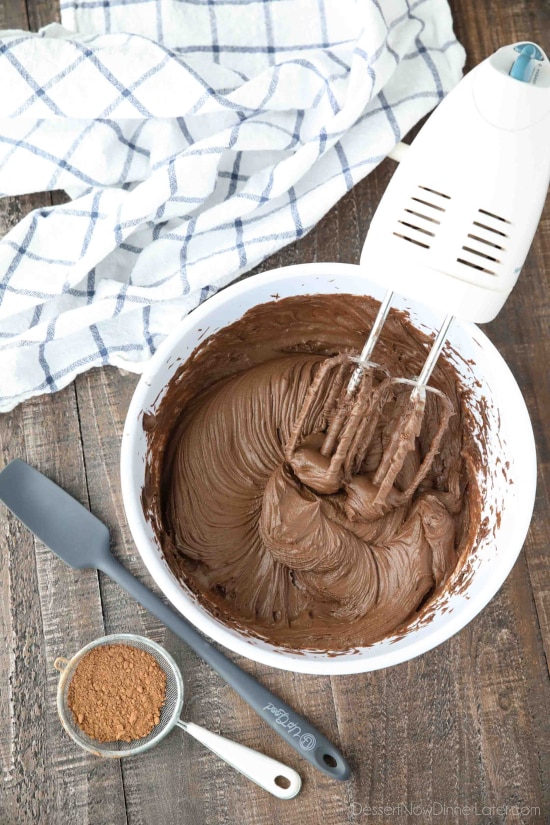 Chocolate cream cheese frosting made in bowl with hand mixer.