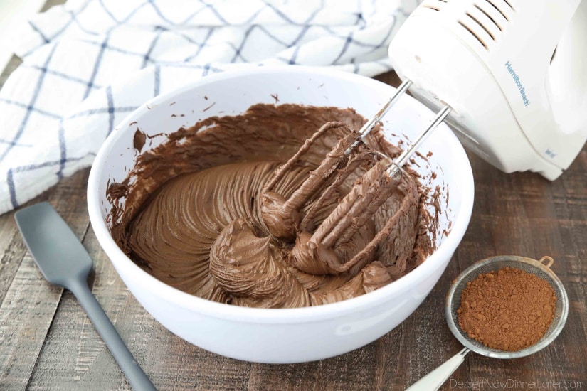 Chocolate cream cheese frosting made in bowl with hand mixer.
