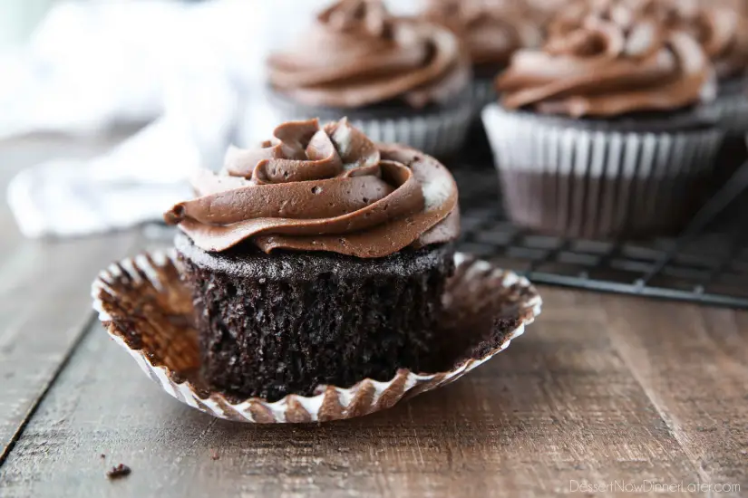 Frosted chocolate cupcake with wrapper peeled down from sides.