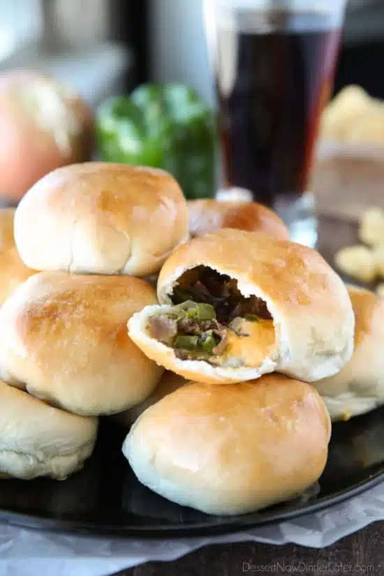 Philly Cheesesteak Bombs roll ripped open with meat, veggies and cheese showing.