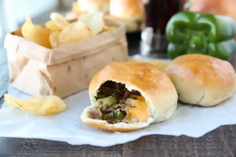 Philly Cheesesteak Bombs roll ripped open with meat, veggies and cheese showing.