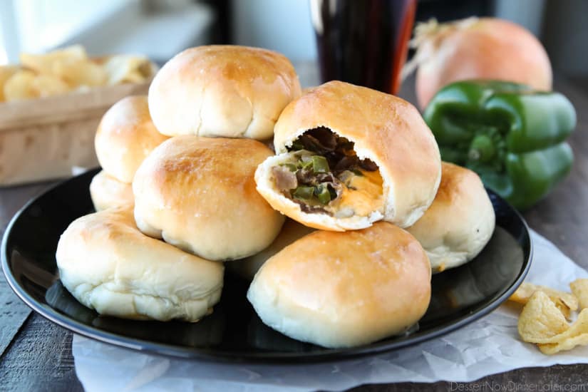 Philly Cheesesteak Bombs roll ripped open with meat, veggies and cheese showing.