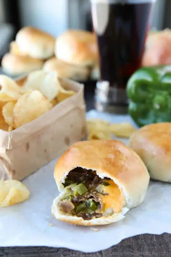 Philly Cheesesteak Bombs roll ripped open with meat, veggies and cheese showing.