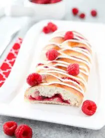 Raspberry Breakfast Braid - a quick raspberry sauce and cream cheese filling are stuffed inside this easy braided bread that's drizzled with a sweet and simple icing. A special breakfast or dessert for weekends or holidays with step-by-step pictures to help you make it.