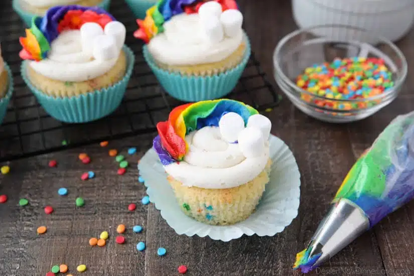 These Funfetti Rainbow Cupcakes are colorful inside and out! Homemade funfetti cupcakes are moist and full of sprinkles. Then topped with a colorful buttercream rainbow and mini marshmallow clouds. Super fun for birthday cupcakes or perfectly festive for St. Patrick's Day!