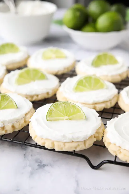 Coconut Lime Sugar Cookies - an easy sugar cookie recipe with a tropical fruit twist. You'll love these moist sugar cookies with a hint of lime, creamy coconut frosting, and a fresh lime wedge to squeeze on top. A Twisted Sugar copycat recipe.