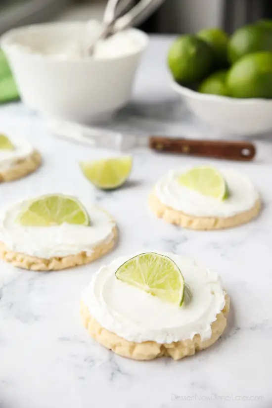 Coconut Lime Sugar Cookies - an easy sugar cookie recipe with a tropical fruit twist. You'll love these moist sugar cookies with a hint of lime, creamy coconut frosting, and a fresh lime wedge to squeeze on top. A Twisted Sugar copycat recipe.