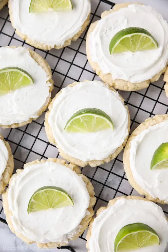 Coconut Lime Sugar Cookies - an easy sugar cookie recipe with a tropical fruit twist. You'll love these moist sugar cookies with a hint of lime, creamy coconut frosting, and a fresh lime wedge to squeeze on top. A Twisted Sugar copycat recipe.