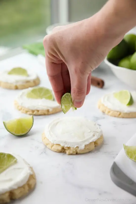 Coconut Lime Sugar Cookies - an easy sugar cookie recipe with a tropical fruit twist. You'll love these moist sugar cookies with a hint of lime, creamy coconut frosting, and a fresh lime wedge to squeeze on top. A Twisted Sugar copycat recipe.