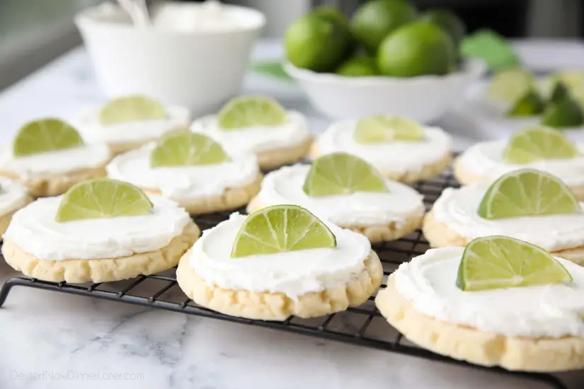 Coconut Lime Sugar Cookies - an easy sugar cookie recipe with a tropical fruit twist. You'll love these moist sugar cookies with a hint of lime, creamy coconut frosting, and a fresh lime wedge to squeeze on top. A Twisted Sugar copycat recipe.