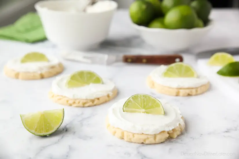 Coconut Lime Sugar Cookies - an easy sugar cookie recipe with a tropical fruit twist. You'll love these moist sugar cookies with a hint of lime, creamy coconut frosting, and a fresh lime wedge to squeeze on top. A Twisted Sugar copycat recipe.