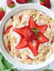 Strawberry Cheesecake Salad is loaded with cream cheese, jello pudding, yogurt, fresh strawberries, and whipped topping then sprinkled with a graham cracker crust. It's a delicious potluck salad, fluff salad, or decadent fruit salad that doubles as a dessert.﻿