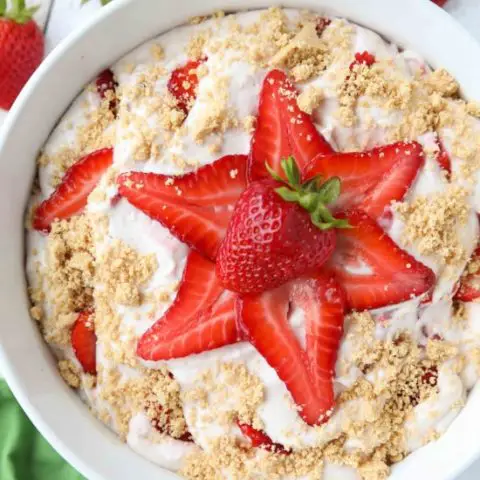 Strawberry Cheesecake Salad is loaded with cream cheese, jello pudding, yogurt, fresh strawberries, and whipped topping then sprinkled with a graham cracker crust. It's a delicious potluck salad, fluff salad, or decadent fruit salad that doubles as a dessert.﻿