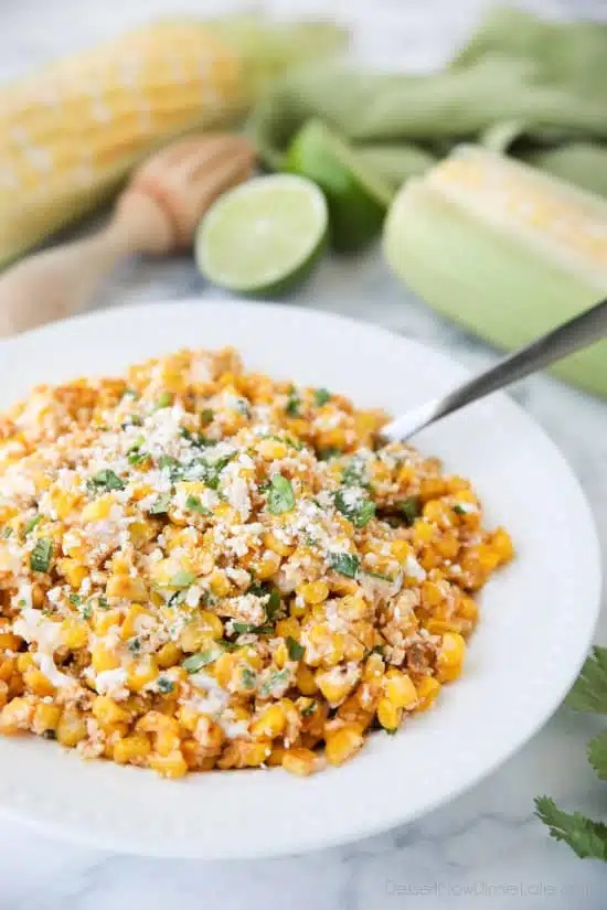 Mexican Street Corn Salad is easy, creamy, and packed with flavor! Your favorite roasted Mexican street corn (Elote) is cut off the cob (to make Esquites) and is served with a spoon, for a delicious summer side dish!