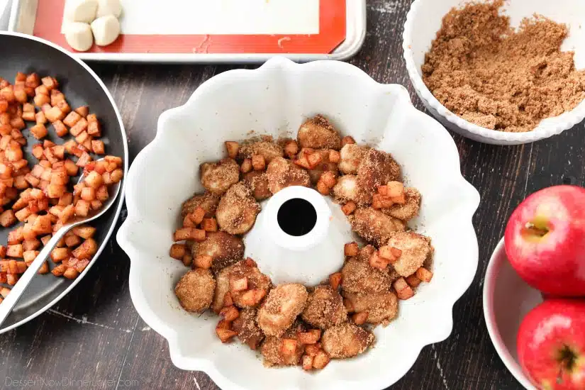 Apple Fritter Monkey Bread - Layering apples with cinnamon-sugar coated bread pieces.