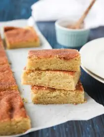 Snickerdoodle Bars transform classic snickerdoodle cookies into easy-to-make blondies. Thick, soft, buttery cookie bars are topped with plenty of cinnamon-sugar. These flavorful, melt-in-your-mouth dessert bars make enough to serve a crowd. Perfect for potlucks, picnics, and parties.