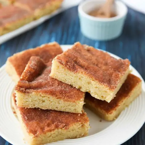 Snickerdoodle Bars transform classic snickerdoodle cookies into easy-to-make blondies. Thick, soft, buttery cookie bars are topped with plenty of cinnamon-sugar. These flavorful, melt-in-your-mouth dessert bars make enough to serve a crowd. Perfect for potlucks, picnics, and parties.