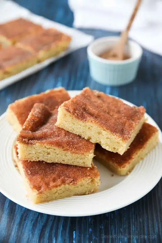 Snickerdoodle Bars transform classic snickerdoodle cookies into easy-to-make blondies. Thick, soft, buttery cookie bars are topped with plenty of cinnamon-sugar. These flavorful, melt-in-your-mouth dessert bars make enough to serve a crowd. Perfect for potlucks, picnics, and parties.