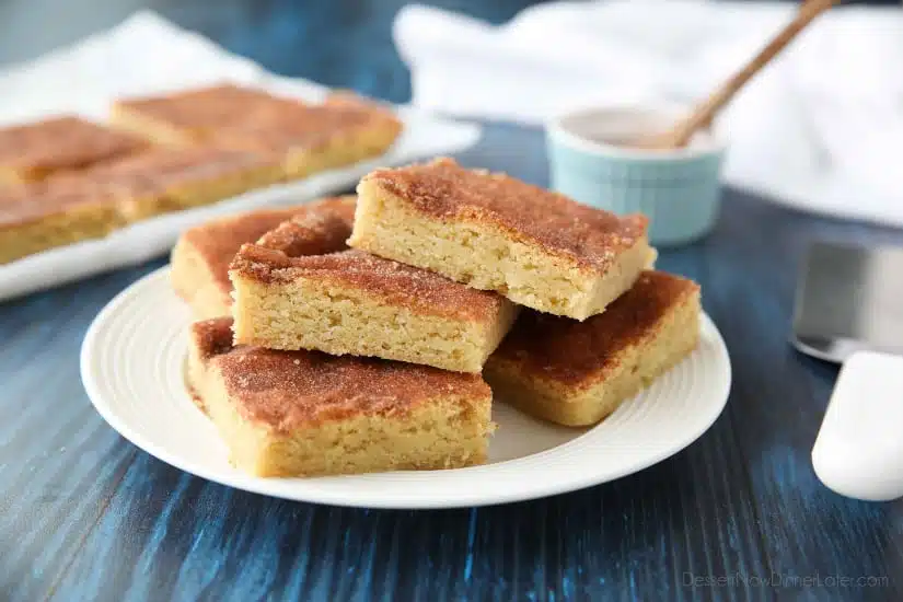 Snickerdoodle Bars transform classic snickerdoodle cookies into easy-to-make blondies. Thick, soft, buttery cookie bars are topped with plenty of cinnamon-sugar. These flavorful, melt-in-your-mouth dessert bars make enough to serve a crowd. Perfect for potlucks, picnics, and parties.