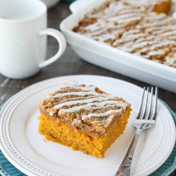Pumpkin Spice Coffee Cake is easy to make and full of real pumpkin and fragrant spices. It's moist, yet light and fluffy, with a cinnamon crumb topping and pumpkin spice icing drizzled on top.