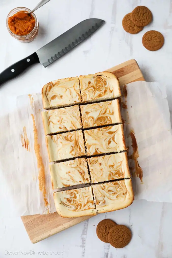 Pumpkin Swirl Cheesecake Bars have a buttery gingersnap crust, with ribbons of creamy vanilla and spiced pumpkin cheesecake marbled on top. A delicious dessert for fall or Thanksgiving.