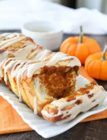 Pumpkin Pull Apart Bread with layers of pumpkin, spices, and real store-bought yeast dough, topped with a cream cheese glaze.