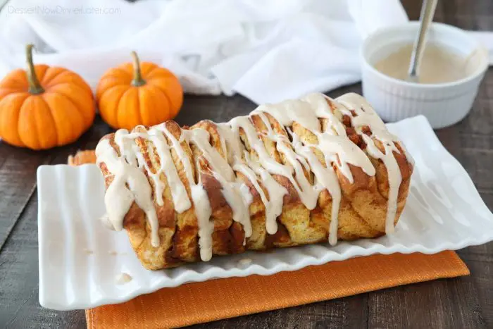 Pumpkin Pull Apart Bread is baked until golden brown and topped with a pumpkin spiced cream cheese glaze.