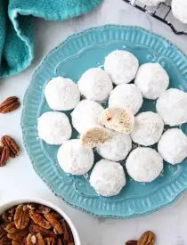 Snowball Cookies are round buttery shortbread cookies with chunks of pecans all rolled in powdered sugar. They melt in your mouth and are a delicious Christmas cookie.