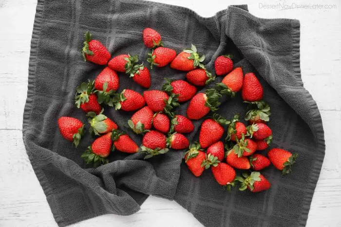 Drying strawberries completely with a towel will ensure the chocolate will stick to the fruit.