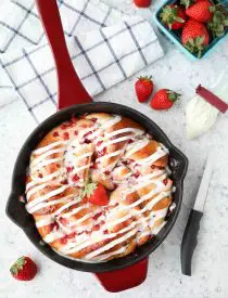 Strawberry Swirl Bread is a twist on classic sweet rolls. Sweet strawberry preserves and chunks of fresh strawberries are twisted inside of soft yeast bread, then baked until golden. Top it with a creamy icing and this easy sweet bread is perfect for breakfast or dessert.