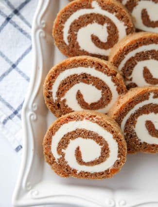 This Carrot Cake Roll is a classic Easter dessert with a twist. Spiced carrot cake is rolled up with the best cream cheese frosting inside. It's beautiful, delicious, and easy to make.