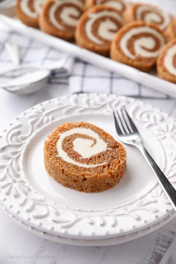 A slice of Carrot Cake Roll with cream cheese frosting inside.