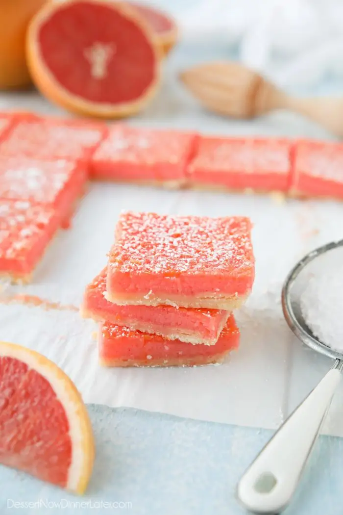 Grapefruit bars (like lemon bars) stacked on top of each other with a dusting of powdered sugar.
