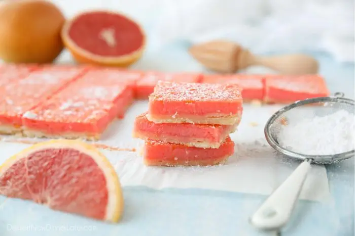 Grapefruit bars (like lemon bars) stacked on top of each other with a dusting of powdered sugar.