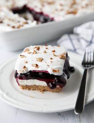 Blueberry Delight (aka Blueberry Lush) is an easy layered dessert with a graham cracker and pecan crust, no bake cheesecake, blueberry pie filling, and cool whip topping. A light, fruity, and delicious summer dessert with minimal baking.