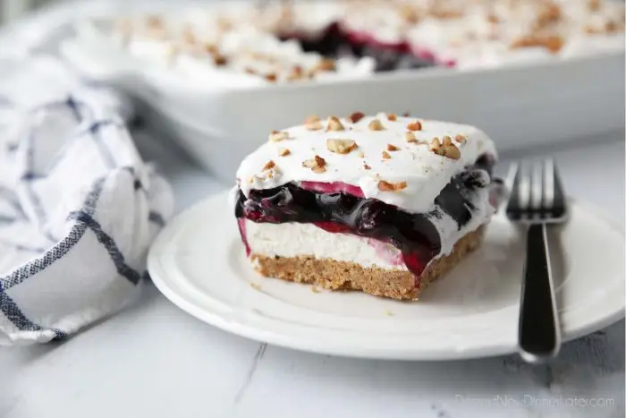 Blueberry Delight (aka Blueberry Lush) is an easy layered dessert with a graham cracker and pecan crust, no bake cheesecake, blueberry pie filling, and cool whip topping. A light, fruity, and delicious summer dessert with minimal baking.