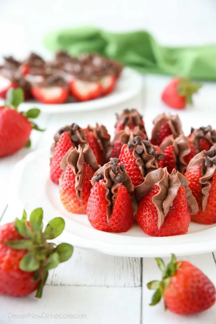 Plate of strawberries filled with no bake chocolate cheesecake filling and topped with mini chocolate chips.