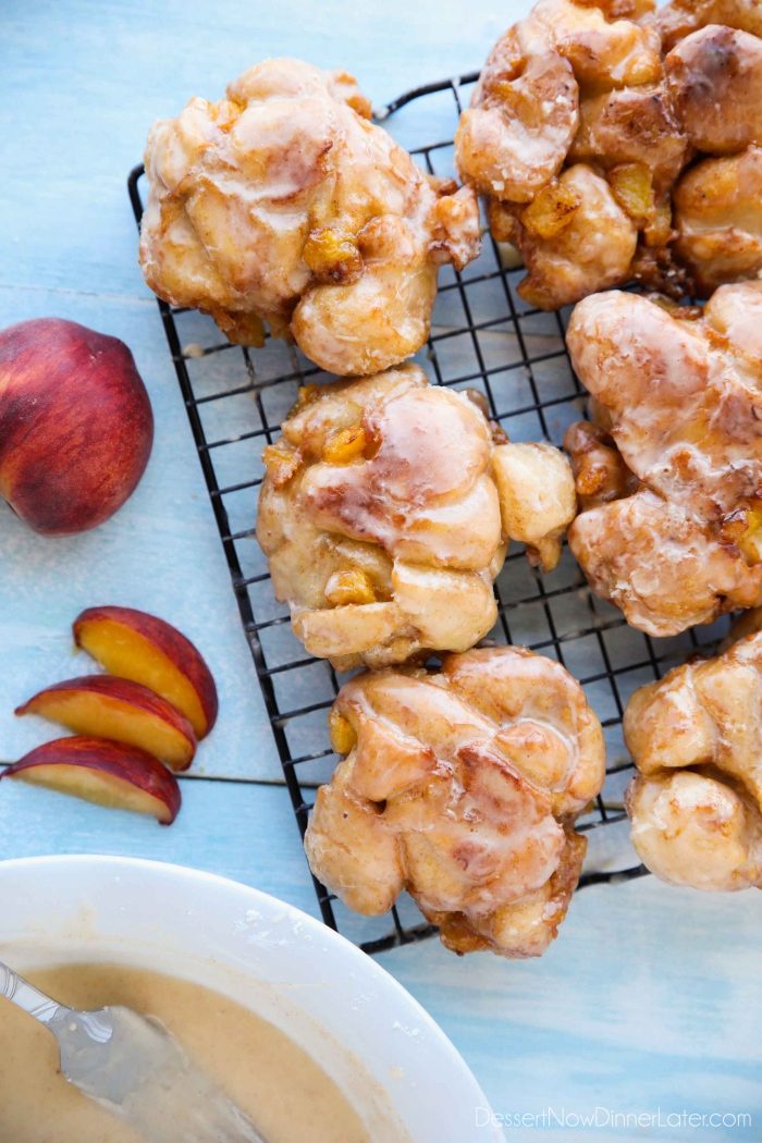 Glazed Peach Fritters Donuts on a cooling rack.