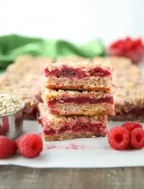 Three Raspberry Crumble Bars stacked on top of each other.