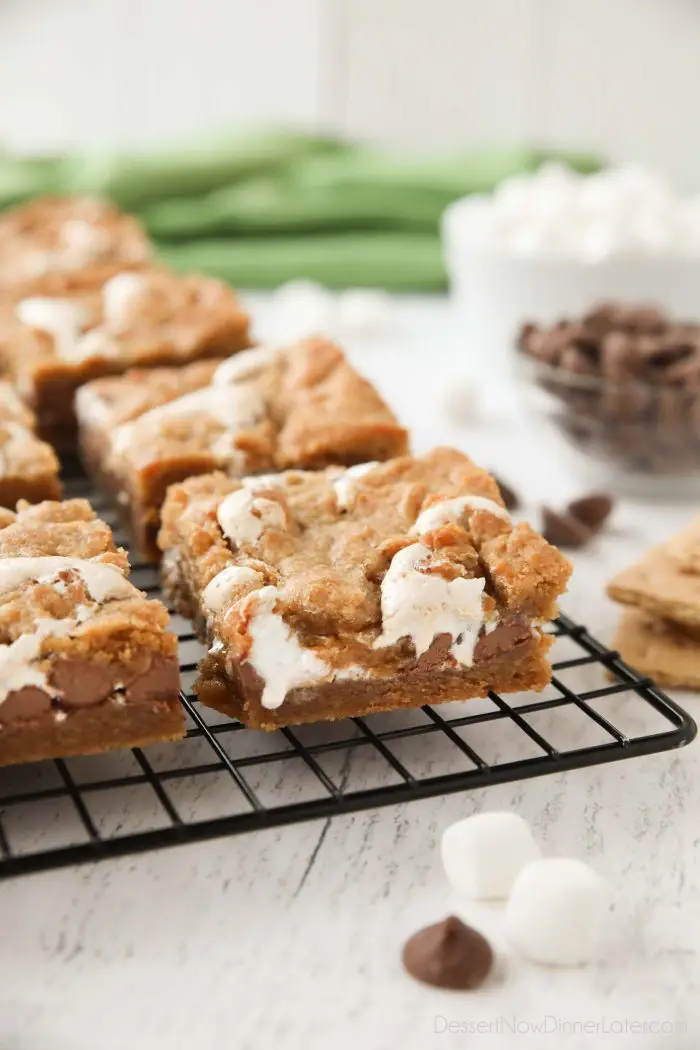 Gooey s'mores bars on a cooling rack with marshmallow fluff and chocolate chips in the center. | Dessert Now Dinner Later