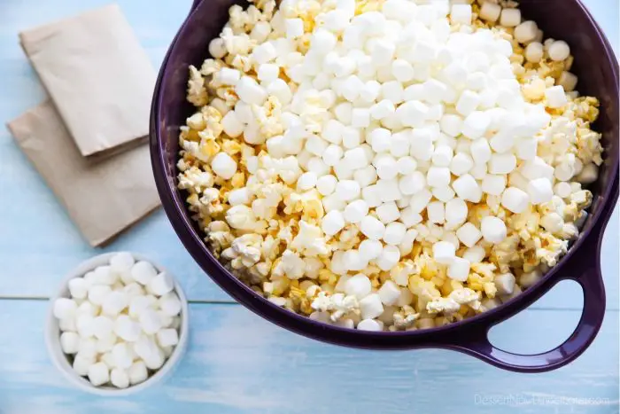 Popcorn and mini marshmallows are placed in a big bowl before mixing.