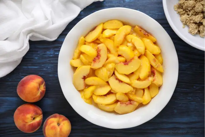 Prepared peaches for Peach Crisp in a 9-inch pie dish. May alternately use an 8 or 9-inch square baking dish.