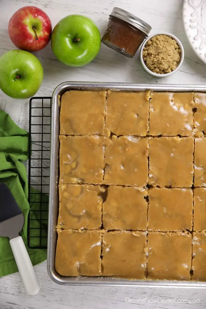 Glazed apple sheet cake in a pan cut into slices.