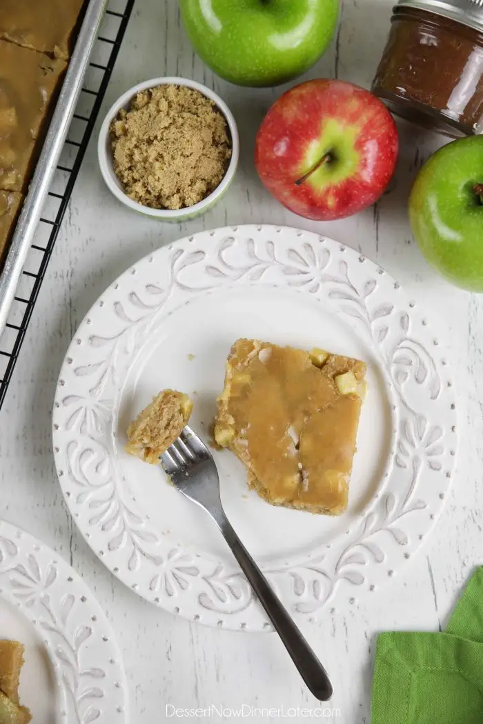 Slice of glazed apple sheet cake on a plate with a fork full of cake.