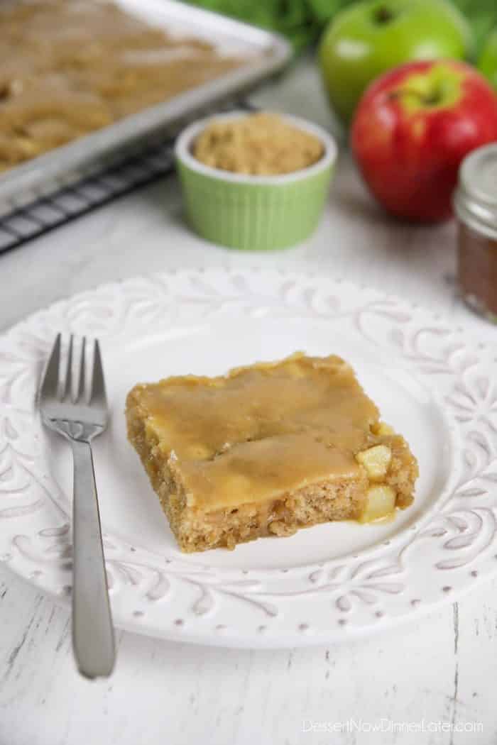 Slice of brown sugar glazed apple sheet cake on a plate with a fork.